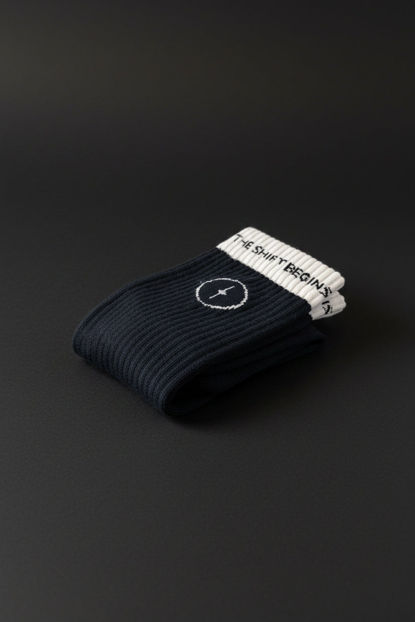 Black sock with white logo and text on a textured surface