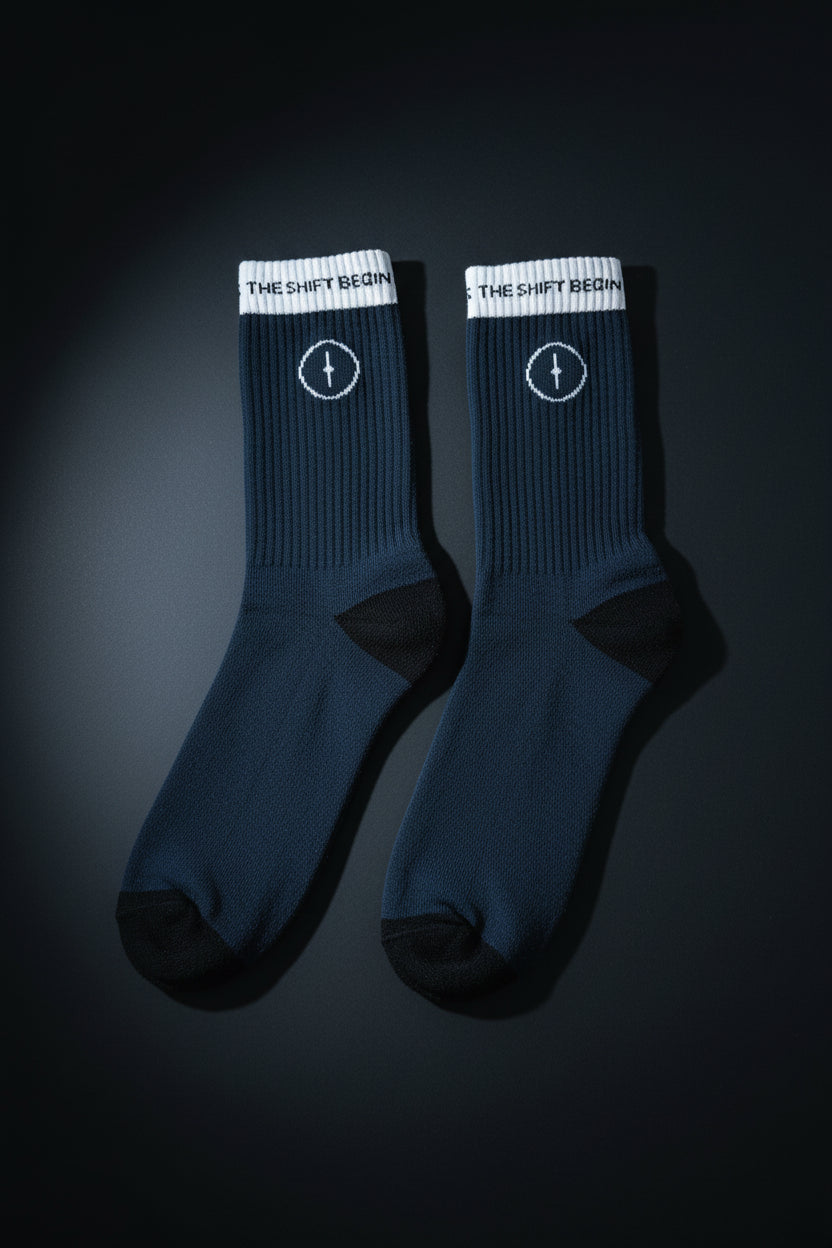 Pair of dark blue socks with white accents on a textured surface