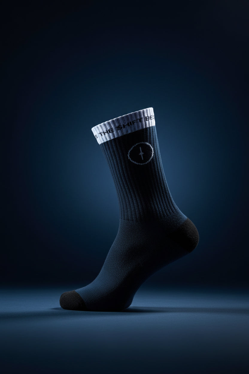 Black sock with a white logo on a wooden floor